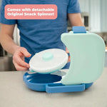 Blue and green snack spinner with detachable lid held by a person in a kitchen setting.