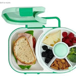 Lunch box with compartments containing a sandwich, fruits, vegetables, and nuts.