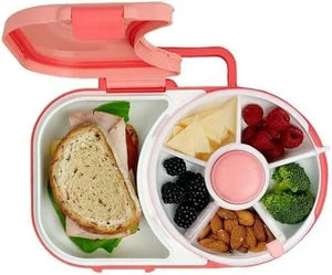 Pink bento box with a sandwich, fruits, and vegetables on a white background
