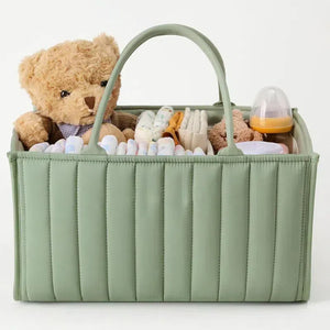 Green baby caddy with teddy bear, diapers, and other items on a white background