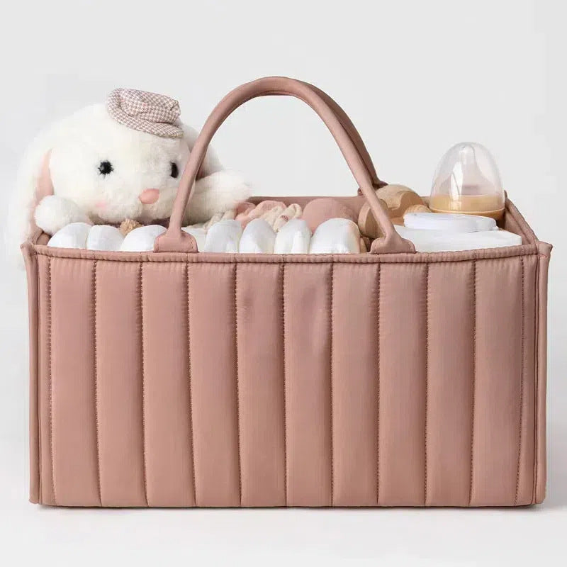 Pink baby organizer with toys and bottles on a light gray background