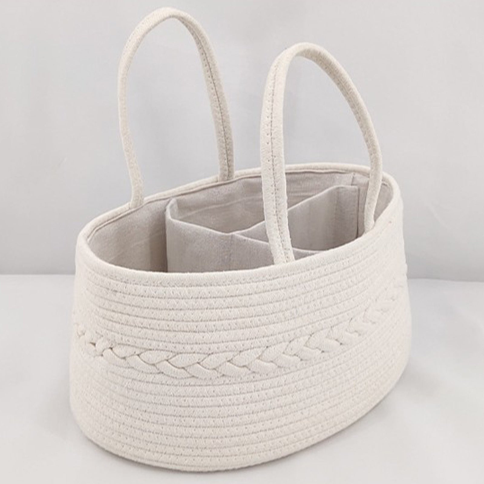 Beige woven basket with handles on a light gray background