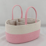 Pink and beige woven basket with handles on a light gray background