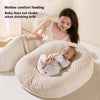 Woman feeding a baby with a bottle on a textured cushion