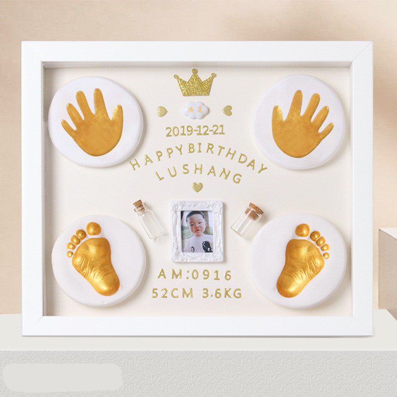 Decorative frame with gold hand and foot prints, a photo, and text on a beige background