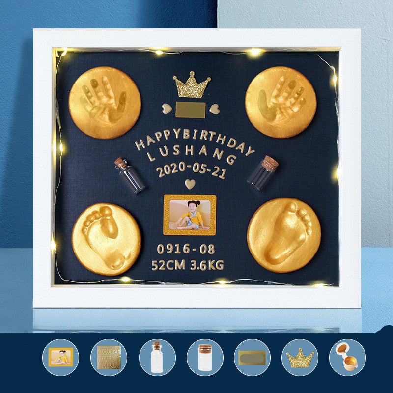 Personalized birthday gift with gold baby footprints and handprints, photo, and text on a dark background.