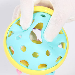 Colorful baby teething ring held by a gloved hand against a light background