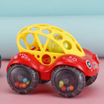 Toy car with a yellow ball on top against a light blue and pink background