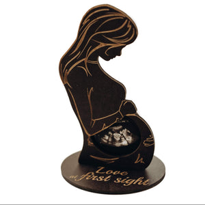 Decorative item with a silhouette of a woman and engraved text on a white background