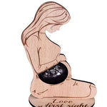Wooden figurine of a couple with engraved text on a white background