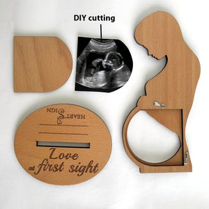 Wooden baby shower gift set with silhouette of a couple and ultrasound photo on a white background