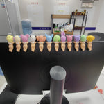 Computer monitor with colorful bear-shaped desk organizers in an office setting