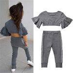 Gray ruffled top and pants set with a child wearing it on a light gray background
