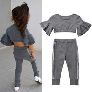 Gray ruffled top and pants set with a child wearing it on a light gray background