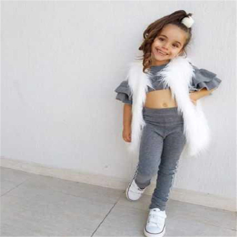 Child wearing a gray outfit with white fur accents against a light background