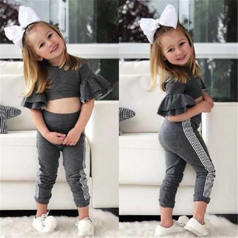 Two images of a young girl in a gray outfit with ruffled sleeves and white bows, sitting on a white couch.