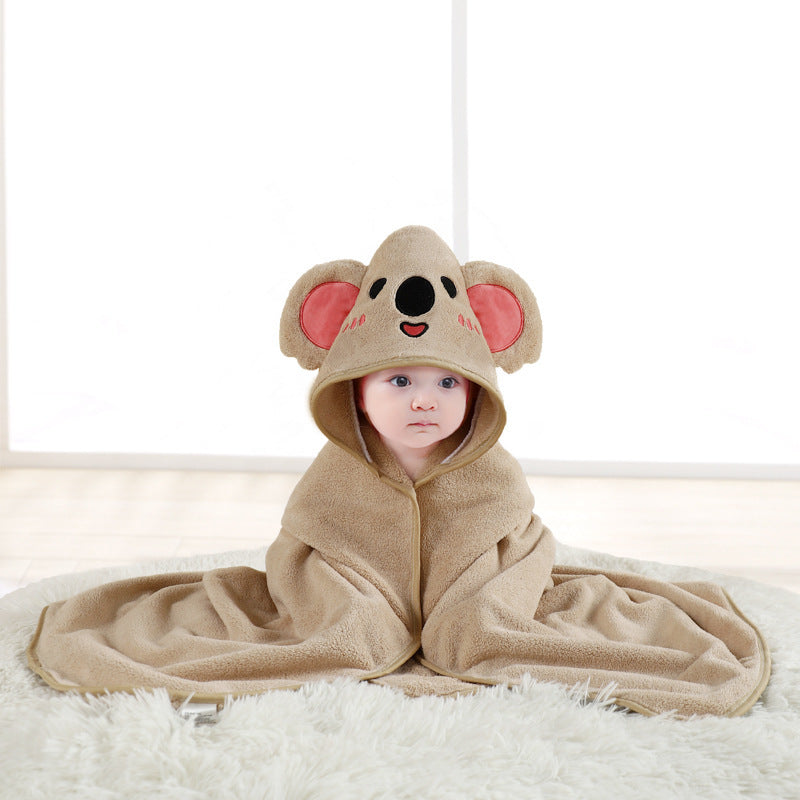 Baby wearing a beige koala hooded towel on a white surface