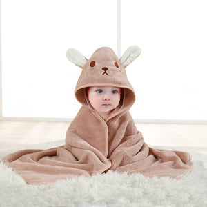 Baby wrapped in a brown hooded towel with bunny ears on a white background