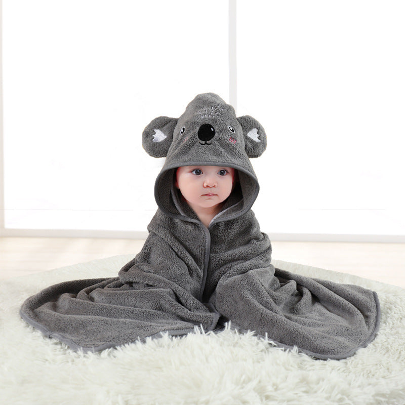 Child wearing a gray koala bear hooded towel on a white surface