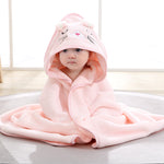 Child wearing a pink hooded blanket with cat ears and a nose on a light background