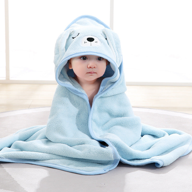 Child wearing a blue hooded towel with bear design on a light background