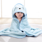 Child wearing a blue hooded towel with bear design on a light background