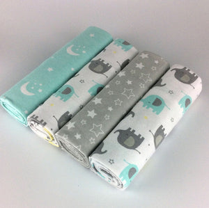 Three rolls of fabric with elephant patterns on a light gray background