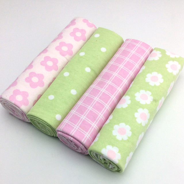 Four rolls of fabric with different patterns on a white background