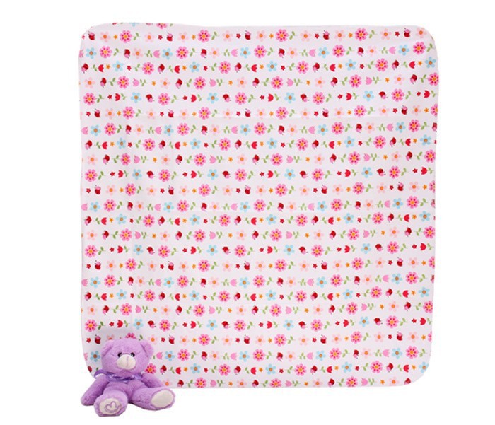Floral-patterned blanket with a purple teddy bear on a white background