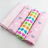 Four folded baby blankets with different patterns on a light gray background