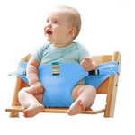 Baby sitting on a wooden stool with a blue baby seat