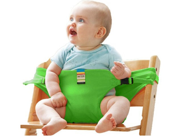 Baby sitting on a green chair with a white background