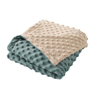 Stack of two textured blankets, one beige and one blue, on a white background