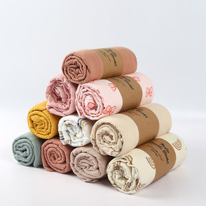 Stack of rolled-up towels with brown paper wrapping on a white background