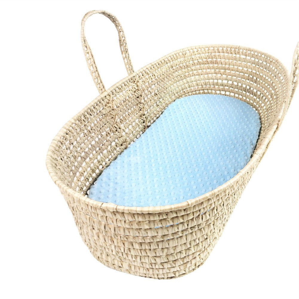 Woven baby crib with a blue mattress on a white background