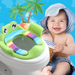 Child sitting on a colorful frog-shaped potty seat with a tropical background