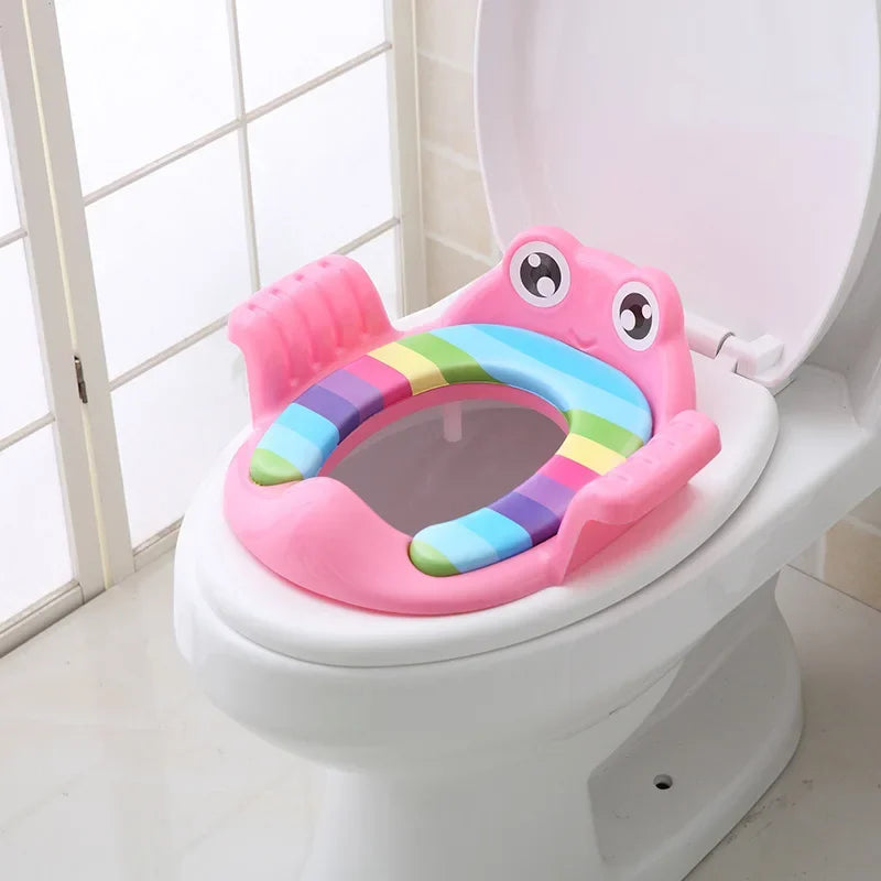 Pink children's toilet seat with rainbow design on a white toilet.
