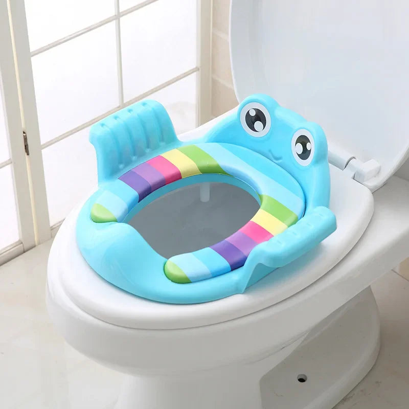 Children's toilet seat with rainbow design and frog face on a toilet