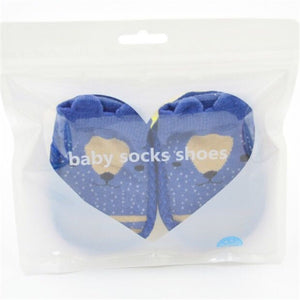 Pair of blue baby socks with bear design in clear packaging