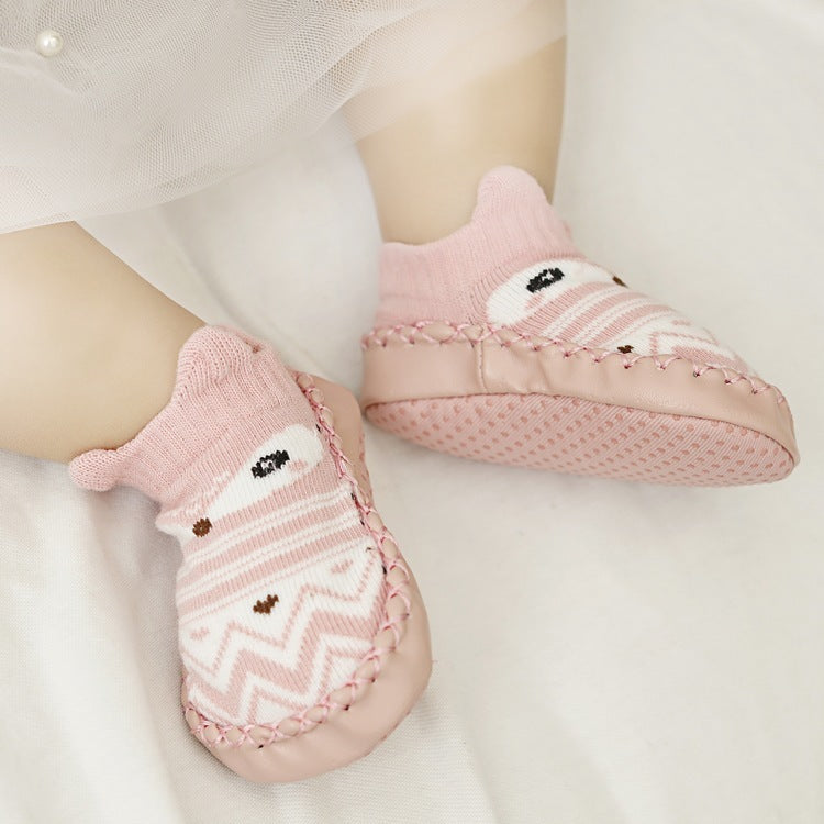 Pink baby socks with cartoon character design on a white background