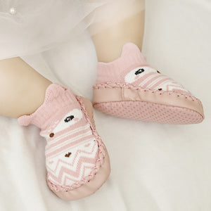 Pink baby socks with cartoon character design on a white background