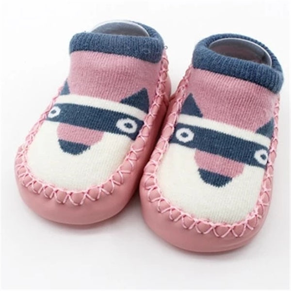 Pair of pink baby shoes with a raccoon design on a white background