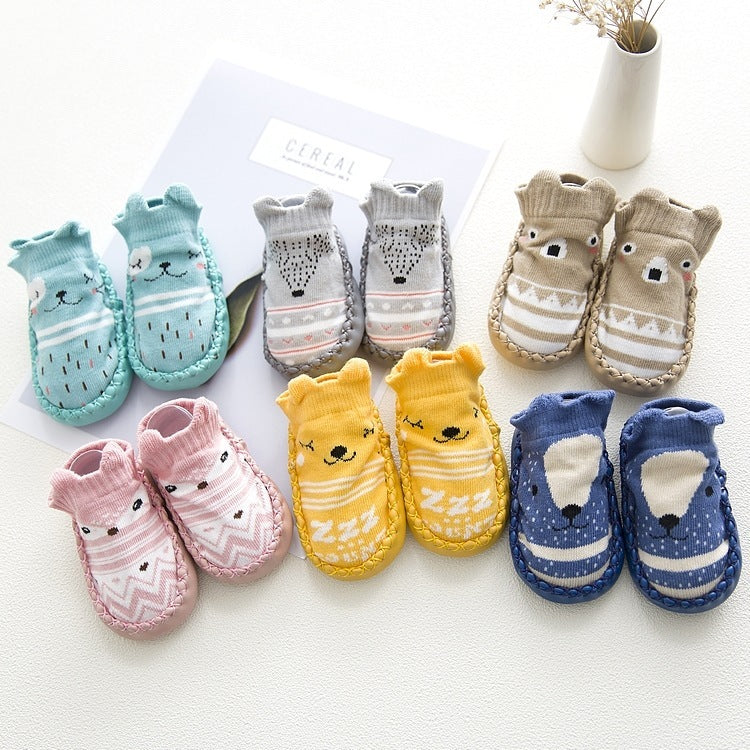 Set of colorful baby socks with animal designs on a white surface.
