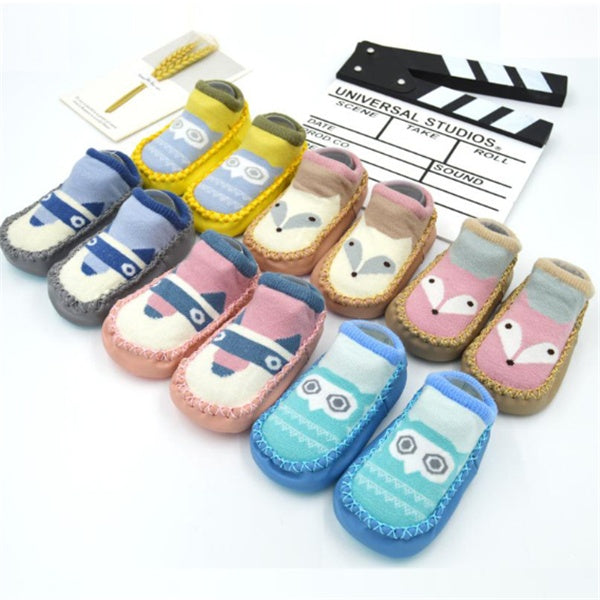 Set of cartoon-themed baby shoes on a white background