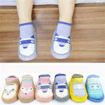 Children's socks with animal designs on a wooden floor.
