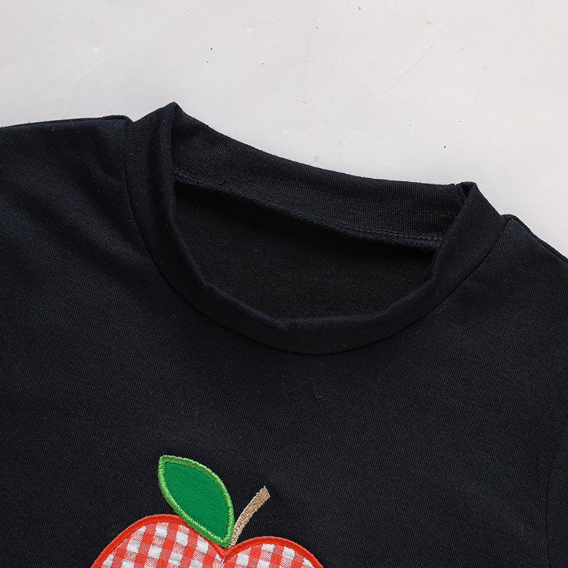 Black shirt with a red apple design on a white background