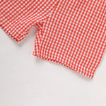 Close-up of a red and white checkered fabric on a light gray background