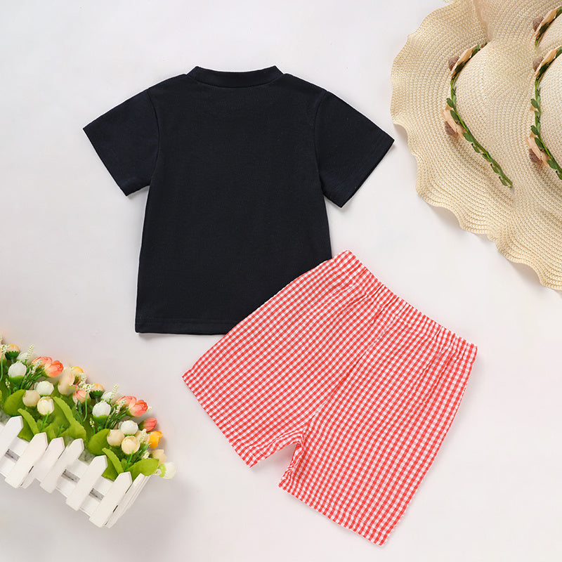 Black t-shirt and red checkered shorts with a straw hat on a light background