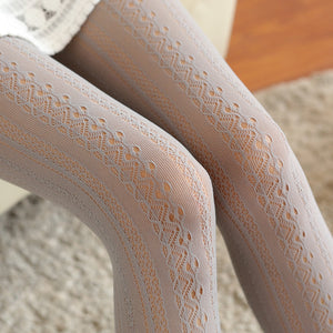 Beige lace-trimmed tights on a textured surface