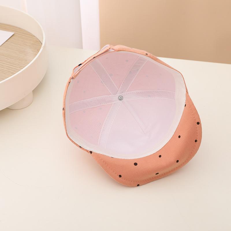 Pink polka dot visor on a light beige background